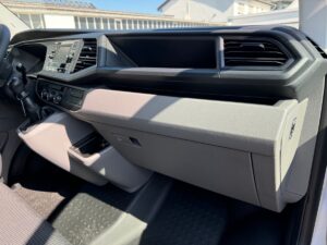 Innenbereich eines modernen, grauen Autos mit innovativem Armaturenbrettdesign und Touchscreen.