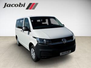 Ein weißer VW-Transporter mit schwarzem Kühlergrill, seitlich abgebildet.