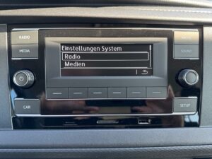 Auto-Display zeigt "Einstellungen System" auf Deutsch, mit Optionen für Radio und Medien.