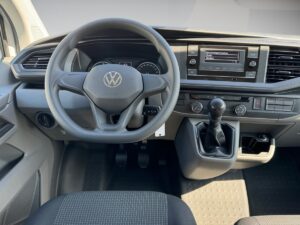 Volkswagen Armaturenbrett mit Lenkrad, Tacho und Schalthebel, moderne schwarze Innenausstattung.