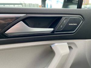 Autotürinnenverkleidung mit Harman Kardon-Lautsprechern in modernem Design, mattschwarz und silber.