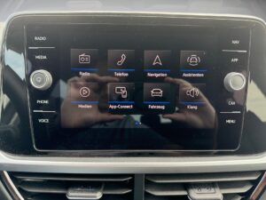 Ein Autoradio in einem Auto mit einem Touchscreen, der verschiedene Apps in Symbolen anzeigt.