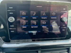 Ein Auto-Infotainment-Display mit verschiedenen Funktionssymbolen, umgeben von einem schwarzen Rahmen.