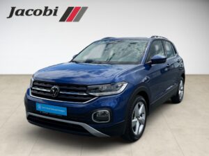 Ein blauer VW T-Cross SUV mit Jacobi-Logo, neutrale Miene.