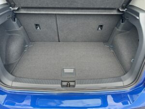 Kofferraum eines Autos in Blau, leer, mit grauem Teppich, sauber und geräumig.