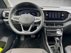 Innenansicht eines modernen VW-Autos mit schwarzem Lenkrad und digitalem Armaturenbrett.