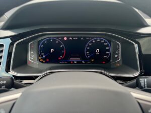 Digitales Armaturenbrett eines Autos, zeigt Tachometer und Anzeigen in Blau und Rot, elegant.