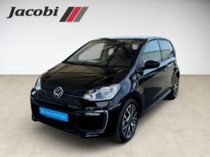 Ein schwarzer Volkswagen Up! in einem Showroom mit Jacobi-Logo, glänzendem Lack und modernen Felgen.