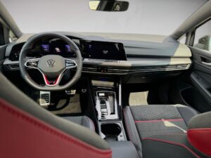 Ein modernes VW-Auto-Interieur mit digitalem Display und einem Lenkrad in Schwarz und Rot.