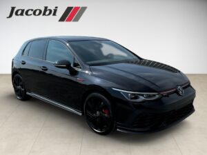 Ein schwarzer VW Golf GTI steht auf hellem Boden vor einer Wand mit "Jacobi"-Logo.