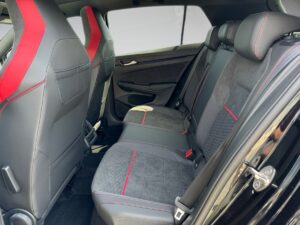 Rückansicht von schwarzen Autositzen mit roten Details und modernen Interieur-Elementen.