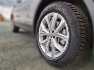 Reifen eines Autos mit VW-Logo und Continental-Markenname in Silber, klar und detailliert.