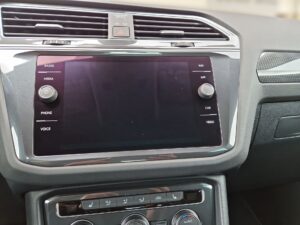 Ein Fahrzeug-Infotainment-System in Schwarz mit Tasten und Drehreglern.