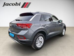 SUV in Grau, seitliche Rückansicht, markantes Rücklichtdesign, Logo "Jacobi" oben links.