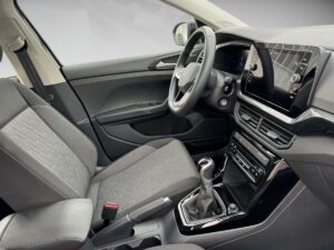 Innenraum eines modernen Autos in neutralen Grautönen, mit digitalem Display und eleganten Stoffen.