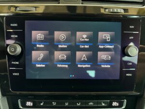 Ein Auto-Infotainment-System mit Touchscreen-Menü, dunkelblauem Hintergrund und vielen Optionen.