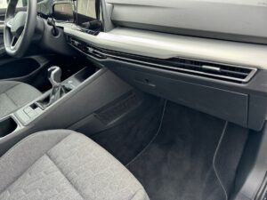 Innenraum eines modernen Autos mit grauen Sitzen, Schalthebel und einem Touchscreen-Display.