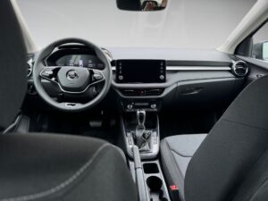 Innenraum eines modernen Autos mit schwarzem Interieur und zentralem Touchscreen im Armaturenbrett.