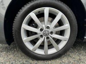 Nahaufnahme eines silbernen VW-Rads mit Goodyear-Reifen auf grauem Kieselsteinboden.