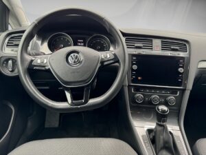 Lenkrad und Armaturenbrett eines Volkswagen-Autos in Schwarz, mit Infotainment-Bildschirm.