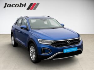 Blauer Volkswagen SUV von vorne, auf Fliesenboden, mit Jacobi-Logo im Hintergrund.