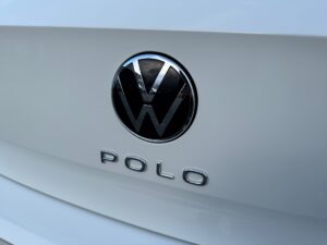 Ein weißer VW Polo mit glänzendem Logo auf dem Heck, schlichte und moderne Gestaltung.