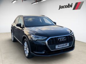 Schwarzer Audi-SUV in einem Ausstellungsraum mit hellem Boden und Jacobi-Logo an der Wand.