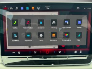 Touchscreen des Infotainmentsystems des Autos, zeigt verschiedene Apps und ist bunt gestaltet.