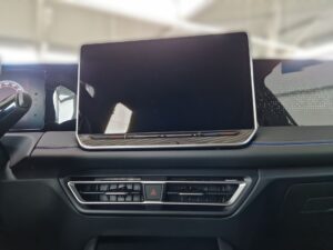 In einem Auto: Großes Touchscreen-Display im Armaturenbrett, dunkel, modernes Design.