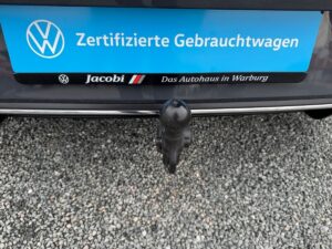 Autoanhängerkupplung, schwarzer Stoßfänger, blaues Schild "Zertifizierte Gebrauchtwagen".