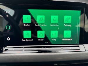 Auto-Infotainment-Bildschirm mit grünen Symbolen und schwarzem Hintergrund.