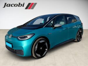 Türkises Volkswagen-Elektroauto vor schlichtem Hintergrund mit Jacobi-Logo oben links.