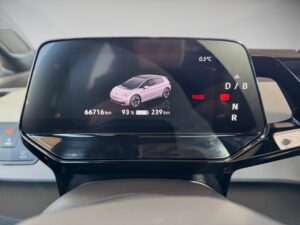 Ein Auto-Display zeigt ein rosa Auto-Symbol, Ladezustand 93 %, Temperatur 0,5 °C, und Kilometerstand.