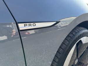 Nahaufnahme eines dunklen Autos mit "PRO"-Emblem und Goodyear-Reifen. Spiegelung auf Lack.