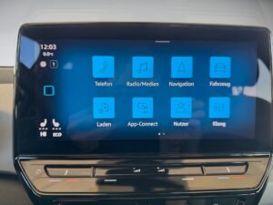 Fahrzeug-Infotainment-Bildschirm, blaues Interface, zeigt Symbole für Telefon, Navigation und mehr.