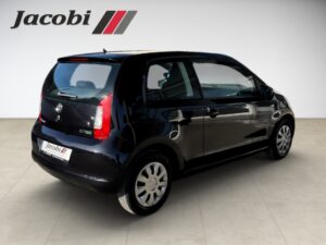 Schwarzes Auto von rechts hinten, mit silbernen Felgen, im Showroom mit "Jacobi"-Logo oben links.