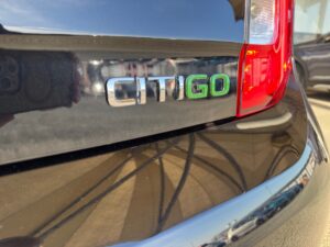 Nahaufnahme eines schwarzen Autos mit dem Emblem "CITIGO" in Chrom und Grün.