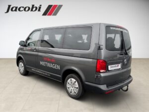 Grauer VW-Transporter bei Händler Jacobi, Seiten- und Heckansicht.