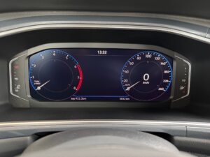 Digitales Armaturenbrett eines Autos mit Geschwindigkeits- und Drehzahlanzeige bei 0 km/h.