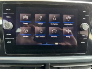 Touchscreen-Infotainmentsystem in einem Auto, zeigt verschiedene Funktionssymbole in Schwarz.