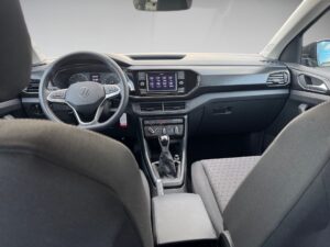 Innenraum eines Wagens mit schwarzem Interieur, modernem Armaturenbrett und Touchscreen-Display.