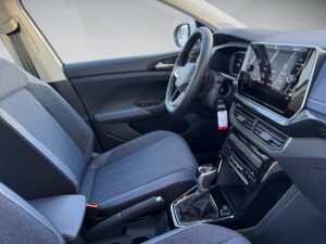 Innenraum eines modernen Autos mit grauer Polsterung, Touchscreen-Display und Schalthebel.