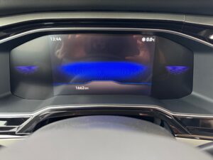 Digitales Armaturenbrett eines Autos, zeigt 0°C und 1662 km, mit blauem Hintergrund.