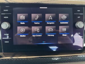 Infortainment System in einem Auto mit mehreren App-Icons auf einem Touchscreen-Display.