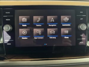 Bildschirm eines Auto-Infotainmentsystems mit Funktionen wie Radio, Telefon und Navigation.