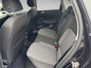 Innenansicht eines Autos mit grauen Stoffbezügen, schwarzem Interieur und klaren Linien.