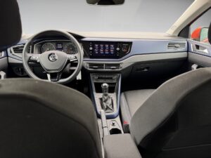 Innenraum eines Autos mit schwarzem Interieur, Armaturenbrett, Lenkrad und Schalthebel sichtbar.