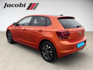 Ein orangefarbenes Auto, seitliche Heckansicht, modernes Design, Logo "Jacobi" oben links.