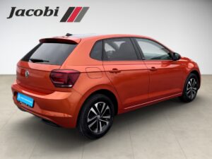 Ein roter Volkswagen Polo, seitliche Heckansicht, auf hell gefliestem Boden.