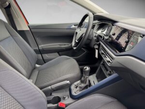 Innenansicht eines Autos mit schwarzem Interieur, modernem Armaturenbrett und manuellem Schalthebel.